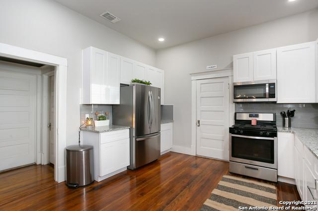 144 Ward Ave, San Antonio, TX 78223 - kitchen featuring backsplash, light stone countertops, stainless steel appliances, and visible vents