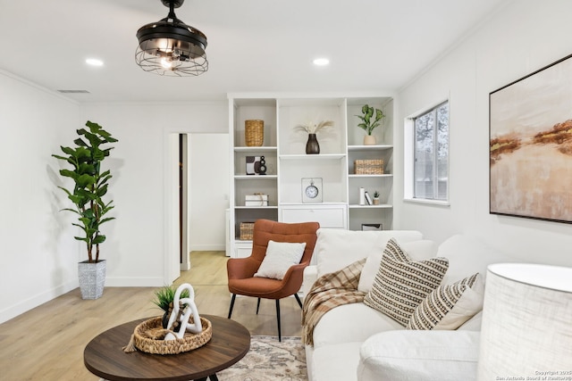 living area with visible vents, light wood-style flooring, baseboards, ornamental molding, and recessed lighting