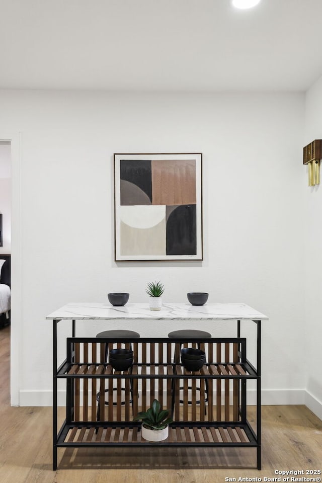 dining space featuring baseboards and wood finished floors