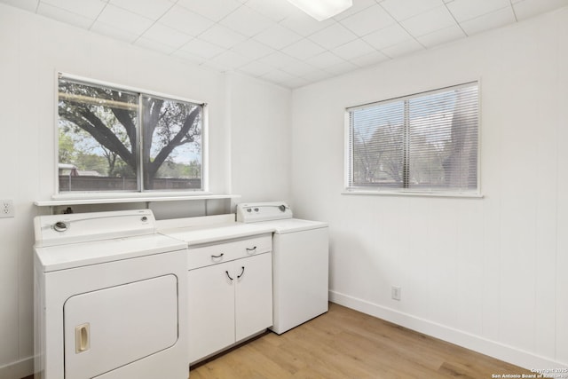 laundry room featuring light wood-style flooring, baseboards, and washing machine and clothes dryer