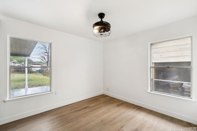 unfurnished room with baseboards and wood finished floors
