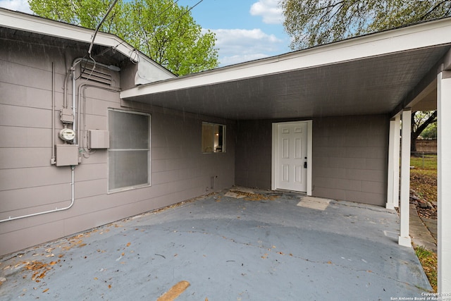 exterior space featuring concrete block siding and a carport