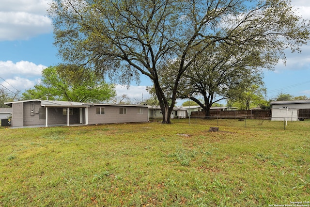 view of yard with central air condition unit, a sunroom, and fence