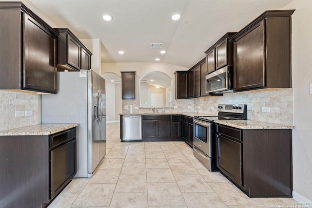 2297 Olive Hl, New Braunfels, TX 78130 - kitchen with visible vents, dark brown cabinetry, arched walkways, and stainless steel appliances