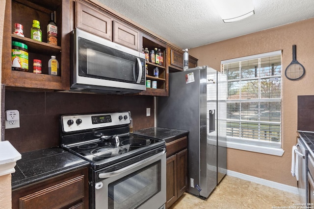 kitchen with stainless steel appliances, a textured ceiling, open shelves, and a wealth of natural light