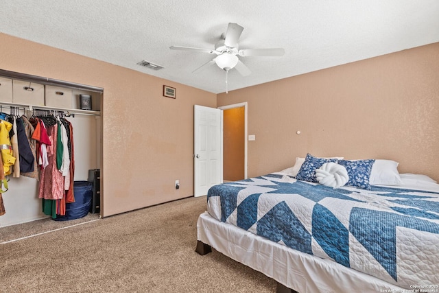 bedroom featuring a textured ceiling, carpet floors, ceiling fan, visible vents, and a closet