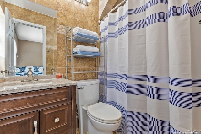 bathroom featuring tile walls, toilet, a shower with shower curtain, and vanity