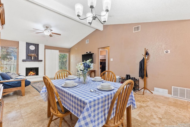 dining room with a fireplace, vaulted ceiling with beams, visible vents, and ceiling fan with notable chandelier