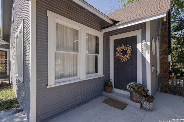 entrance to property with a shingled roof