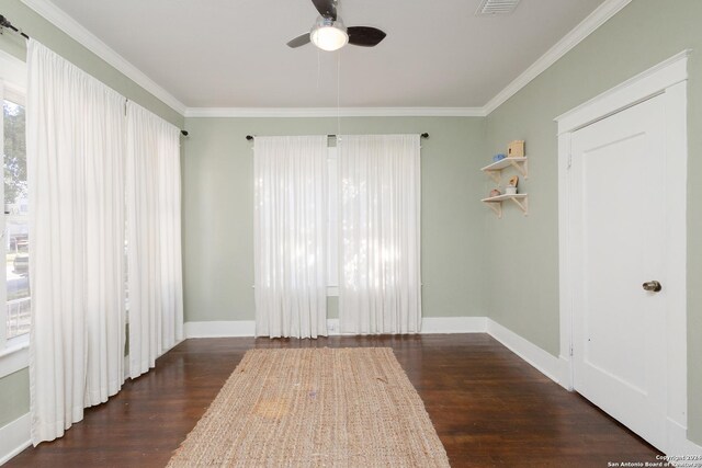 spare room featuring a ceiling fan, crown molding, baseboards, and wood finished floors