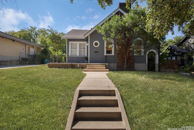 view of front of home with a front yard and fence