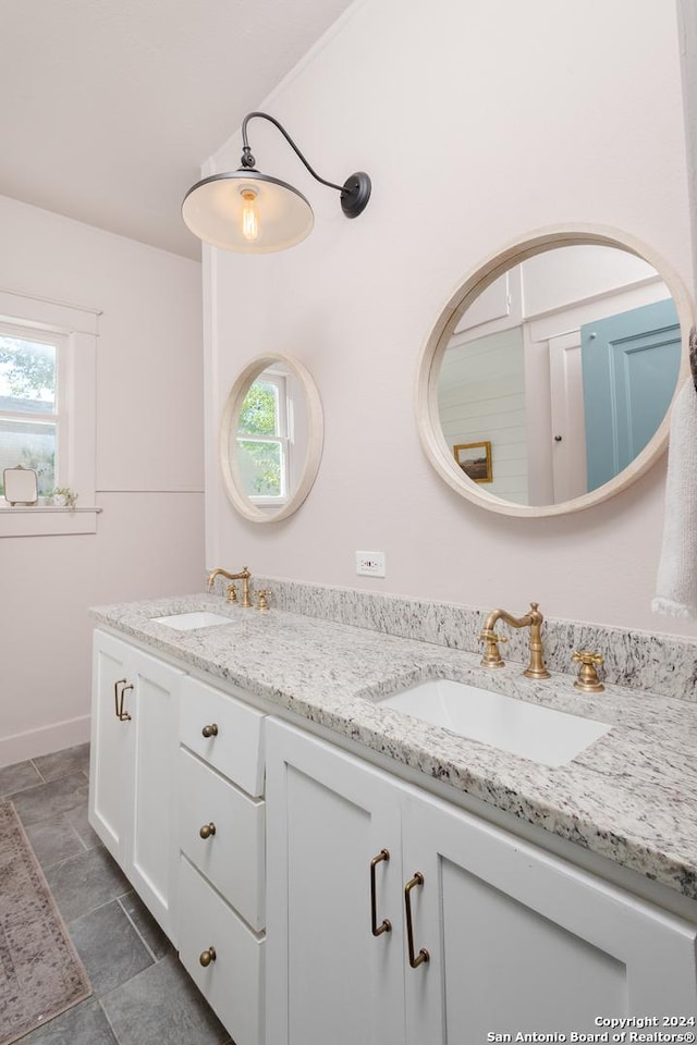 full bathroom with double vanity and a sink