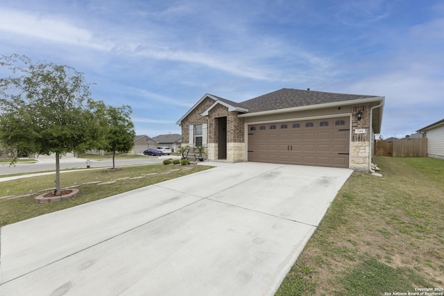 view of front of property with driveway, a front yard, stone siding, fence, and an attached garage