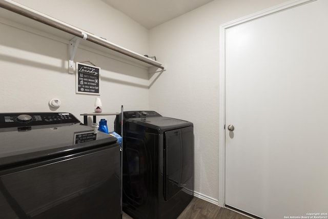 clothes washing area with dark wood finished floors, independent washer and dryer, and laundry area