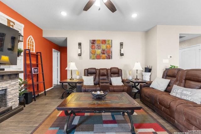 living room featuring wood finished floors, recessed lighting, a stone fireplace, and ceiling fan