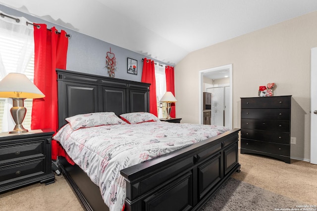 bedroom with connected bathroom, light colored carpet, and vaulted ceiling