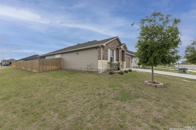 view of home's exterior with driveway, an attached garage, fence, and a lawn