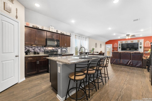 kitchen featuring dark brown cabinetry, stainless steel range with electric stovetop, black microwave, and dark wood-style flooring