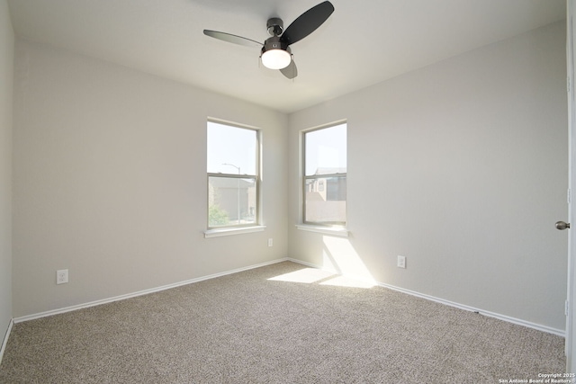 carpeted empty room with baseboards and a ceiling fan
