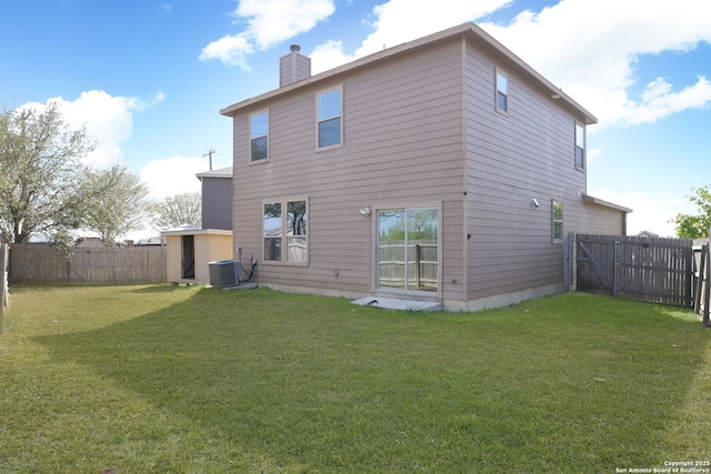 rear view of house with a chimney, cooling unit, a yard, and a fenced backyard