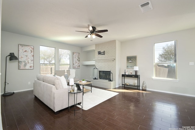 living area featuring a ceiling fan, wood finished floors, a healthy amount of sunlight, and visible vents
