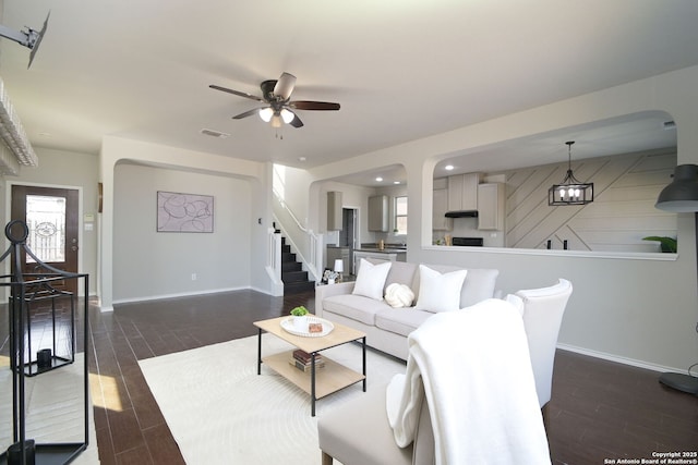 living room with visible vents, ceiling fan, wood tiled floor, and stairway