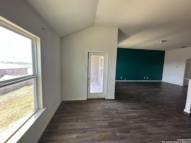 unfurnished room with baseboards, lofted ceiling, and dark wood finished floors