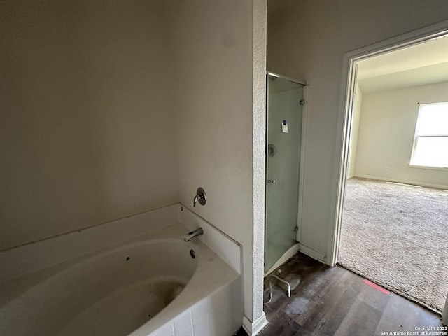 full bath with wood finished floors, a garden tub, and a shower stall