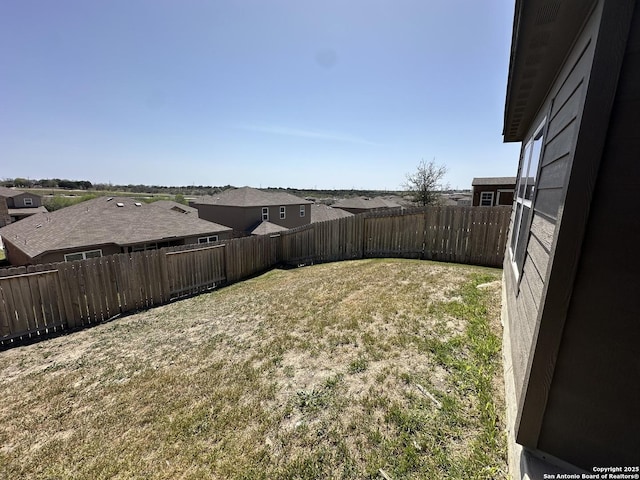 view of yard with a fenced backyard and a residential view