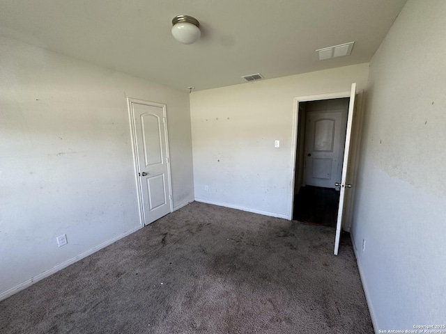 empty room with baseboards, visible vents, and carpet floors