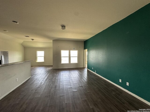 spare room with dark wood-style flooring and baseboards