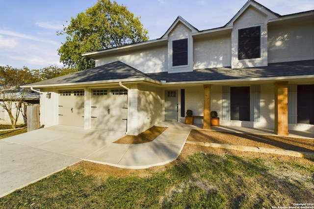 traditional-style house with covered porch, driveway, and an attached garage