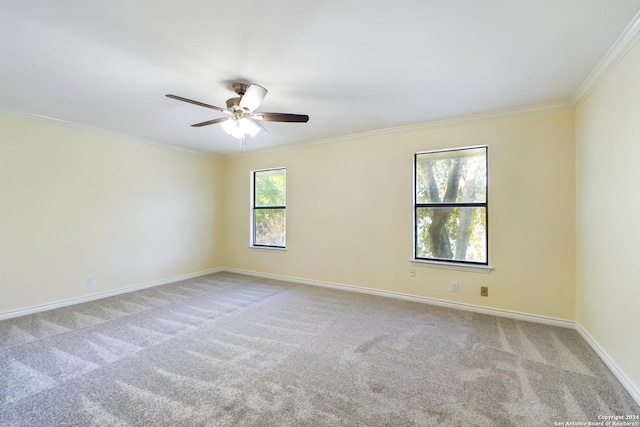 spare room with carpet floors, ornamental molding, baseboards, and ceiling fan