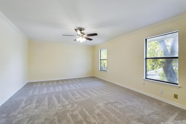 unfurnished room featuring a ceiling fan, light carpet, crown molding, and baseboards