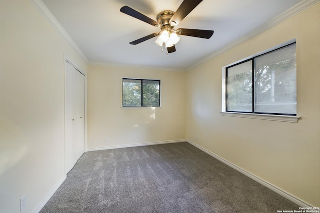 unfurnished bedroom featuring a closet, carpet flooring, a ceiling fan, baseboards, and ornamental molding