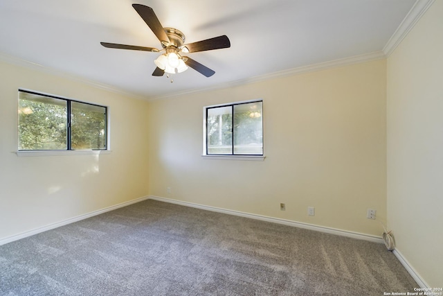 carpeted empty room featuring a ceiling fan, crown molding, and baseboards