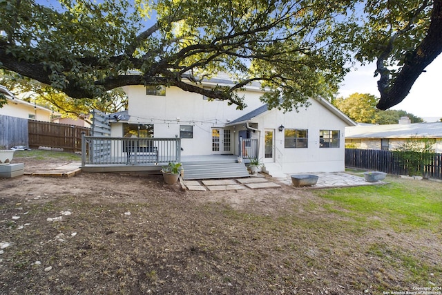 rear view of property with a fenced backyard, a patio, stucco siding, and a wooden deck