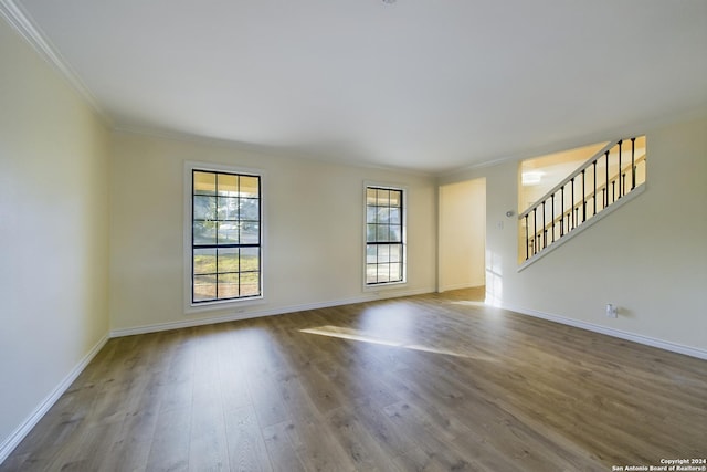 interior space with baseboards, stairs, wood finished floors, and crown molding