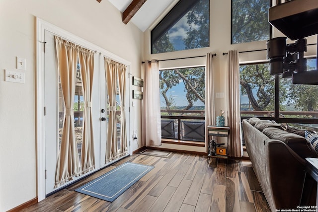 interior space featuring high vaulted ceiling, french doors, wood finished floors, baseboards, and beamed ceiling