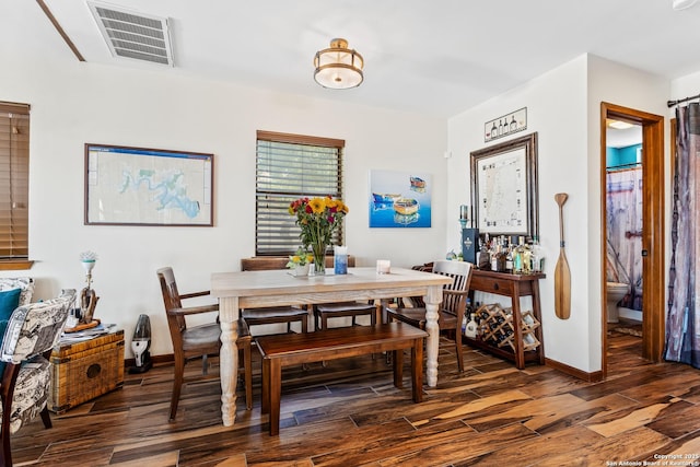 dining space featuring baseboards, visible vents, and wood finished floors