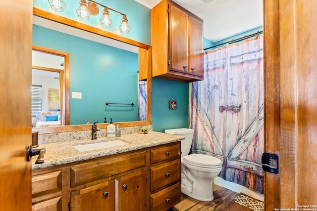 bathroom with curtained shower, toilet, vanity, and wood finished floors