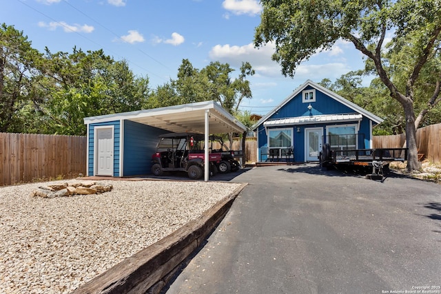 view of car parking featuring fence and aphalt driveway