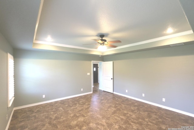 empty room featuring crown molding, a raised ceiling, ceiling fan, and baseboards