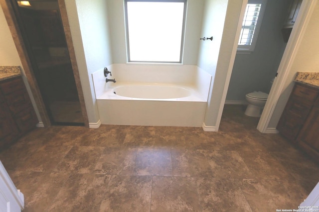 bathroom with toilet, a shower stall, a garden tub, and vanity