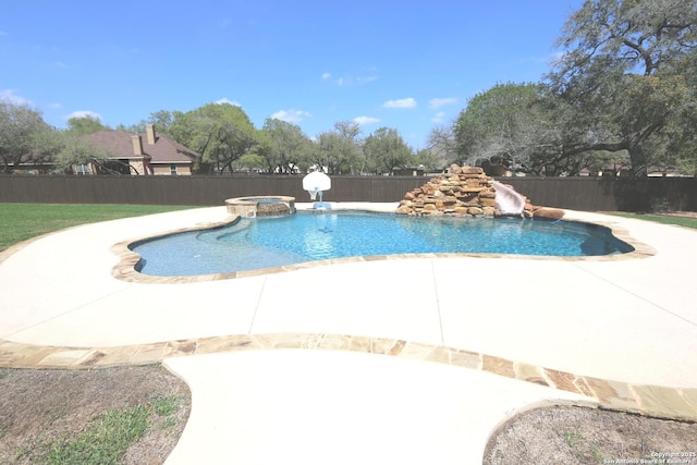 view of swimming pool with a fenced backyard, a patio area, a water slide, and a pool with connected hot tub