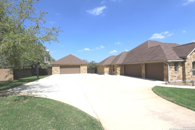 view of front of house with a shingled roof, a front lawn, fence, and stone siding