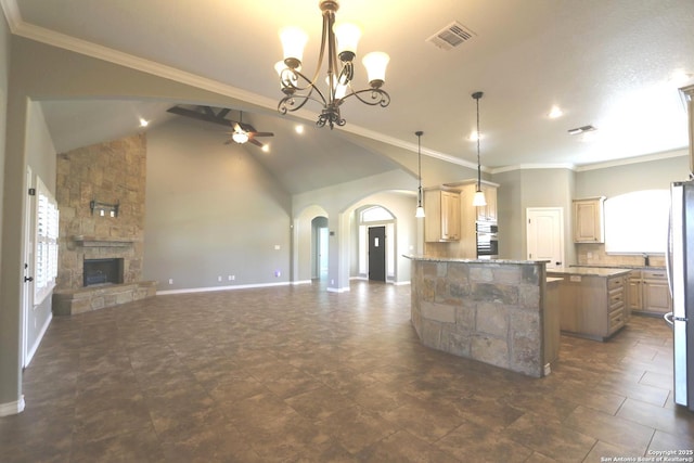 kitchen featuring arched walkways, plenty of natural light, ceiling fan with notable chandelier, open floor plan, and visible vents