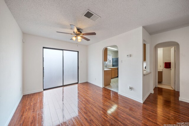 9911 Alexa Pl, San Antonio, TX 78251 - unfurnished bedroom with a sink, arched walkways, hardwood / wood-style flooring, visible vents, and ensuite bathroom