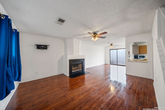 9911 Alexa Pl, San Antonio, TX 78251 - unfurnished living room with a fireplace with flush hearth, a textured ceiling, visible vents, ceiling fan, and wood finished floors
