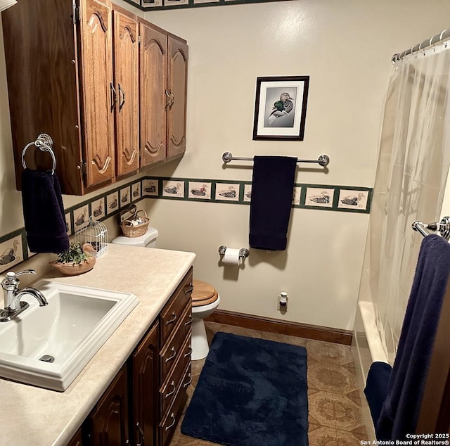 full bath with baseboards, toilet, and vanity
